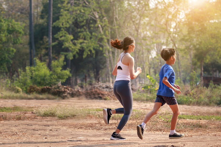 Young woman and boy go for a run outdoors.