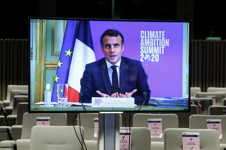 A TV screen broadcasts Emmanuel Macron's speech to a supposedly empty room.