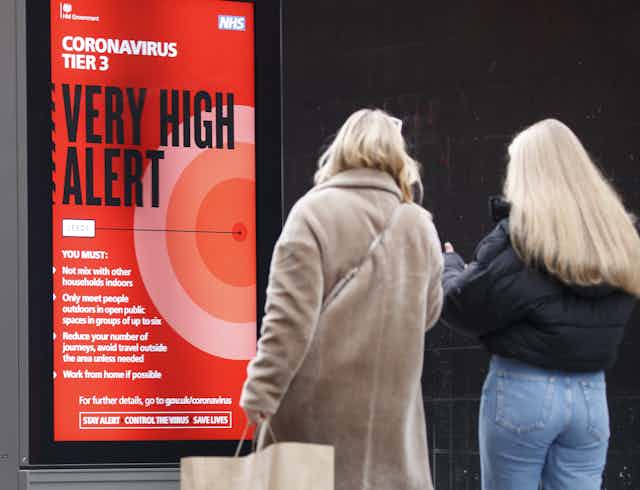 A red sign warning people that they are in a very high alert level area during the coronavirus pandemic. 
