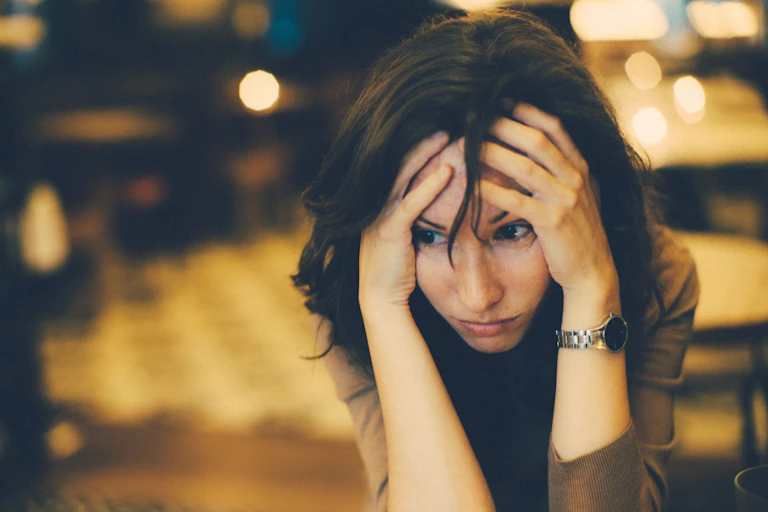 Woman holding her head in her hands