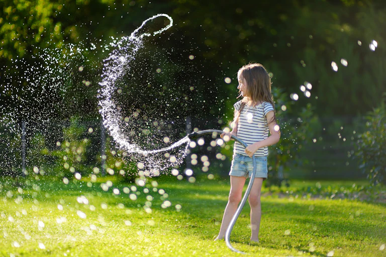 Girl playing with garden hose