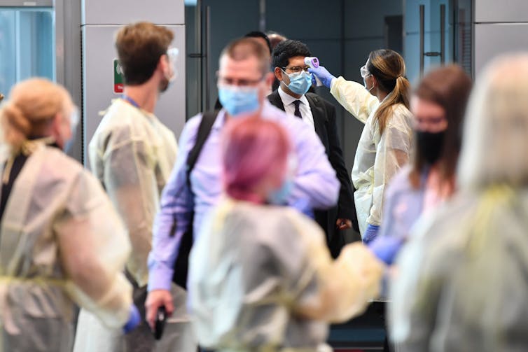 Airport travellers receiving temperature checks