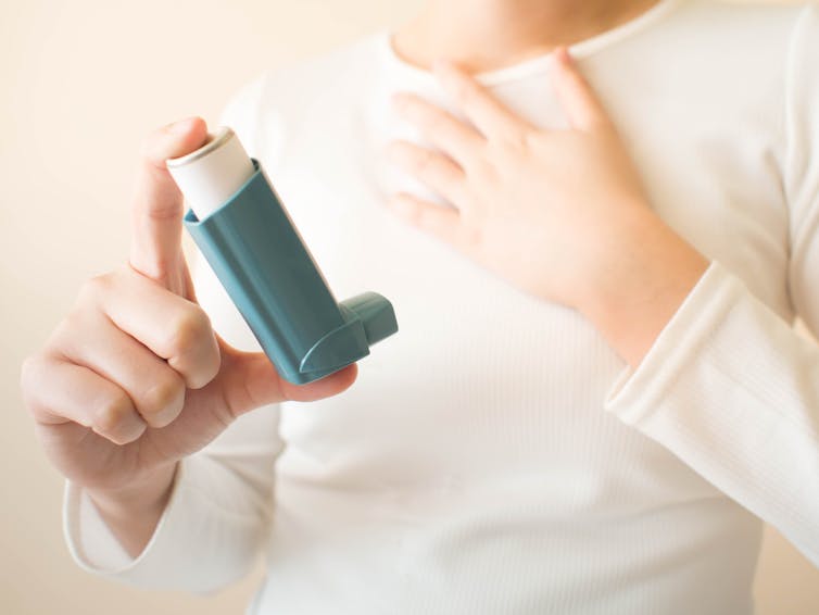 A child holding an asthma inhaler