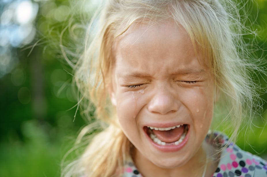 A blonde-haired girl crying.