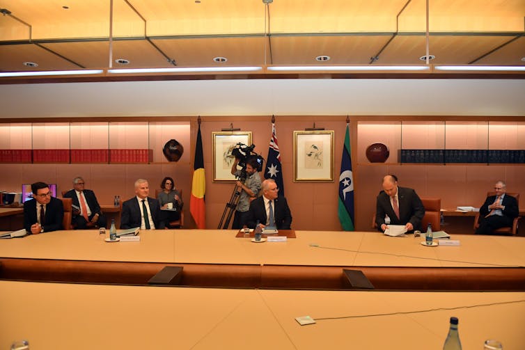 Prime Minister Scott Morrison flanked by Josh Frydenberg and Michael McCormack at a cabinet meeting.