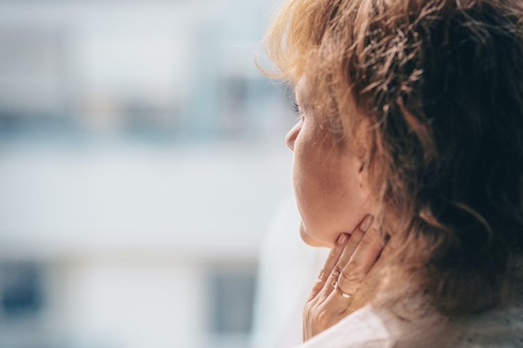 Isolated young woman staring out of window