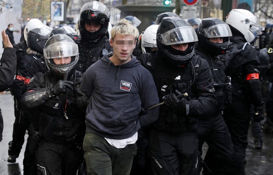 Les policiers français de la Brigade de répression des actions violentes BRAV arrêtent un manifestant