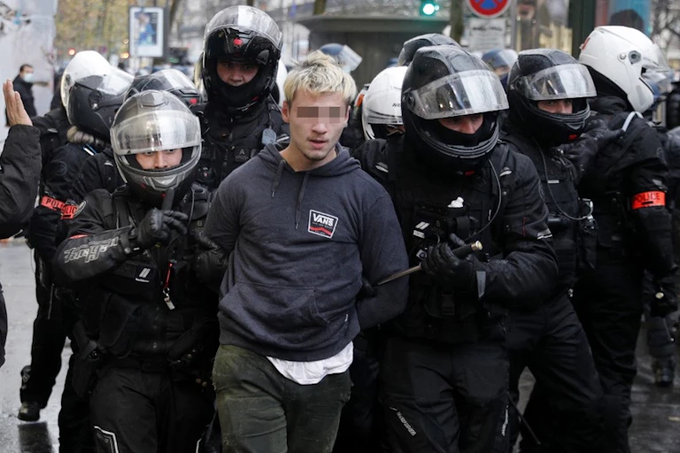 Les policiers français de la Brigade de répression des actions violentes BRAV arrêtent un manifestant