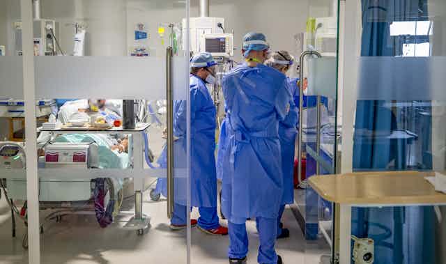 Hospital workers in full PPE in a ward. 