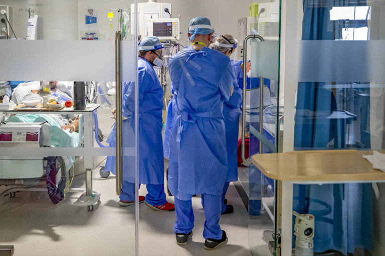 Hospital workers in full PPE in a ward.