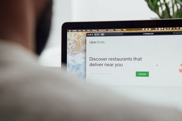A man looks at the Uber Eats app on his laptop