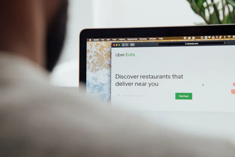 A man looks at the Uber Eats app on his laptop