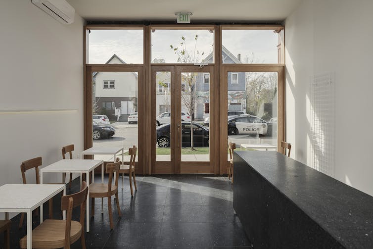 Ceiling-to-floor windows and compact tables are features of the cafe.