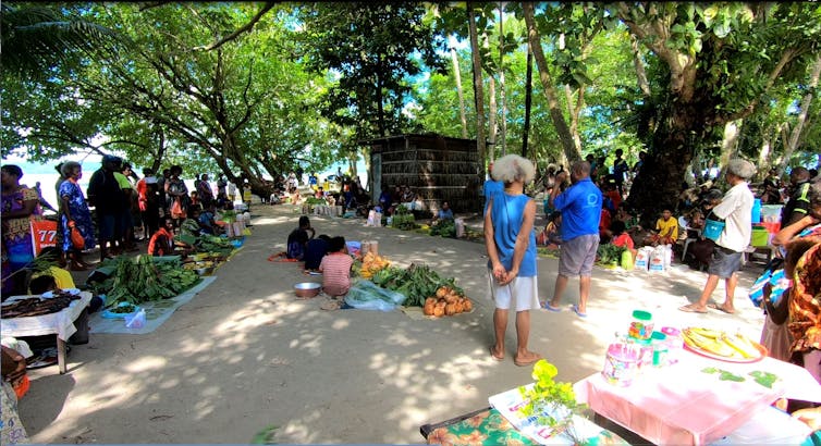 People gather at community markets on tropical atoll island