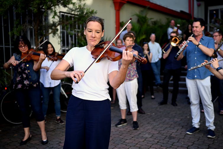 Musicians play music outside in casual clothes