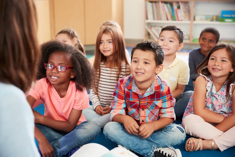 Kindergarten kids listening intently to the teacher.