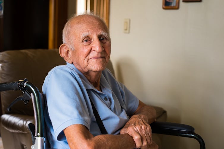 An elderly man sitting in a wheelchair.