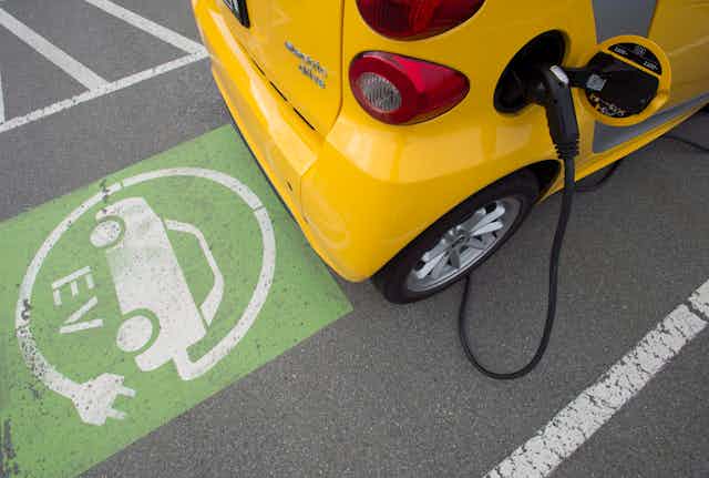 A yellow electric vehicle being charged