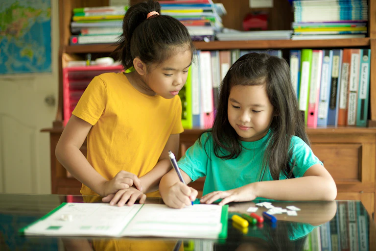 Two girls looking at school workbook