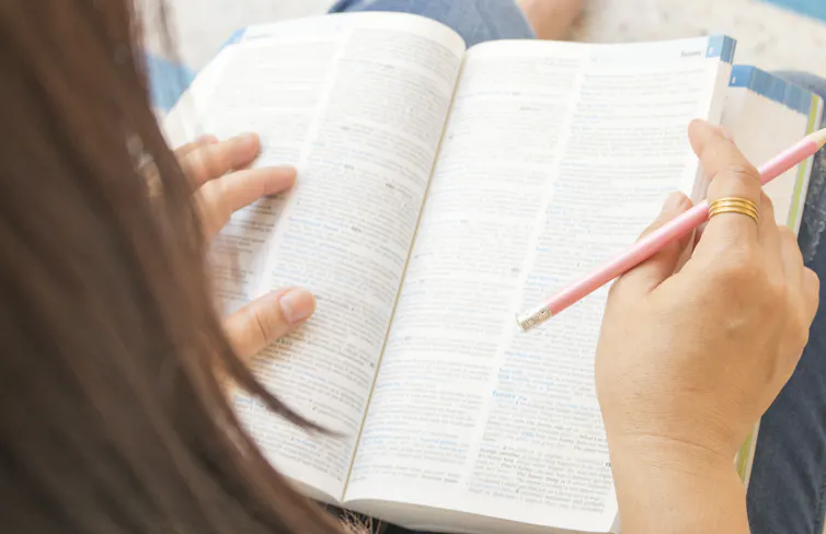Woman looking in dictionary.