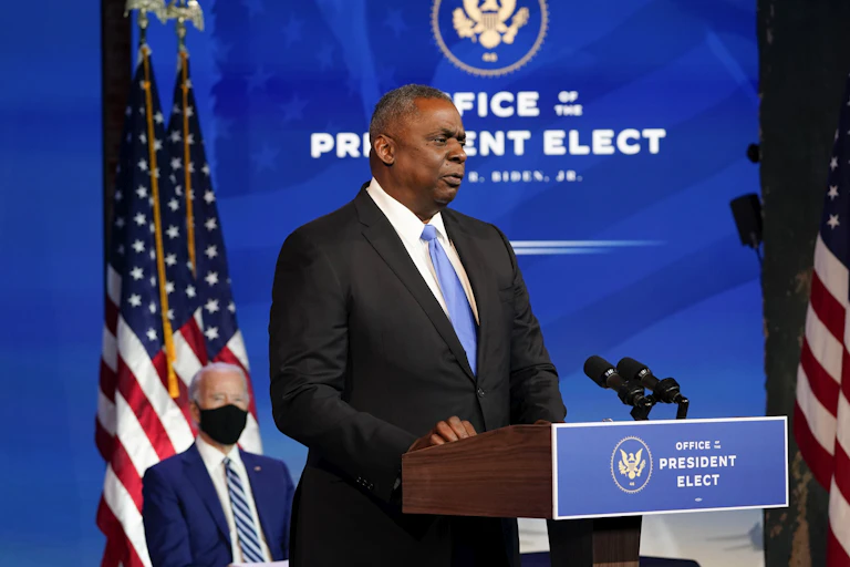 Retired Gen. Lloyd Austin speaks as President-elect Joe Biden looks on