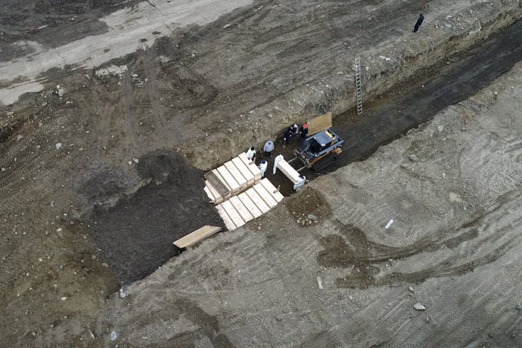 Bodies of people who died with COVID-19 are buried in a trench on Hart Island, in the Bronx borough of New York, on April 9 2020.