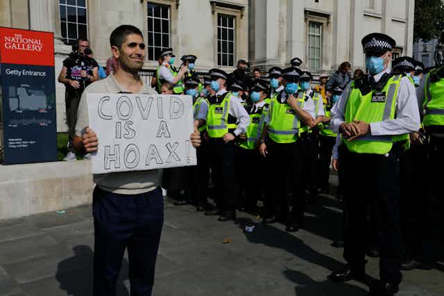 Manifestantes en Londres con pancarta que dice que covid es un bulo.