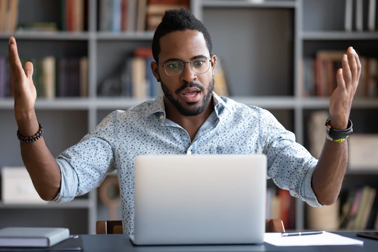 Man looks frustrated at his laptop.