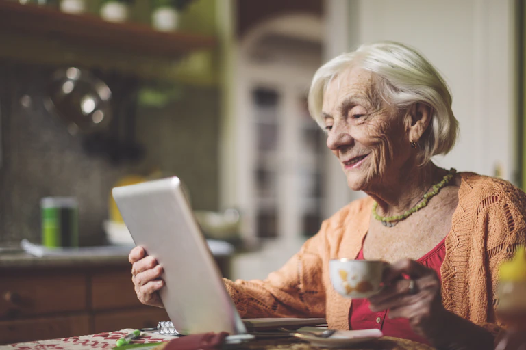 An older woman using a tablet..