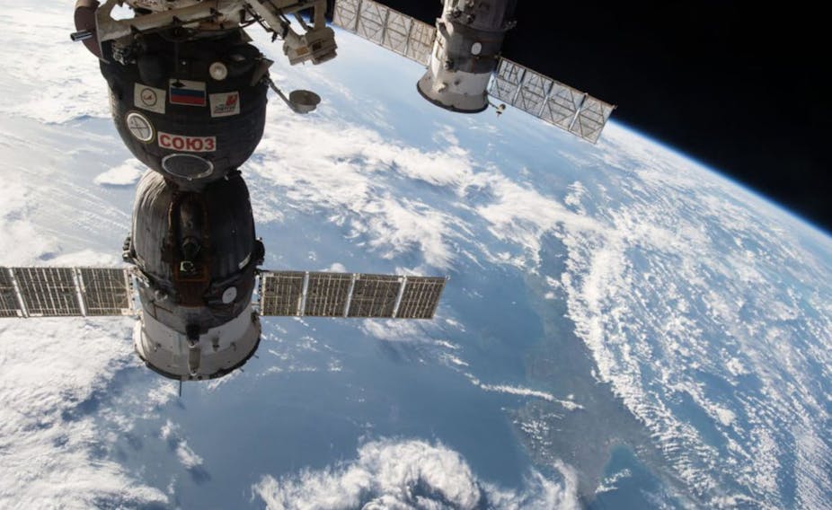 The Soyuz TMA-15M spacecraft and the ISS Progress cargo craft float above the Earth.