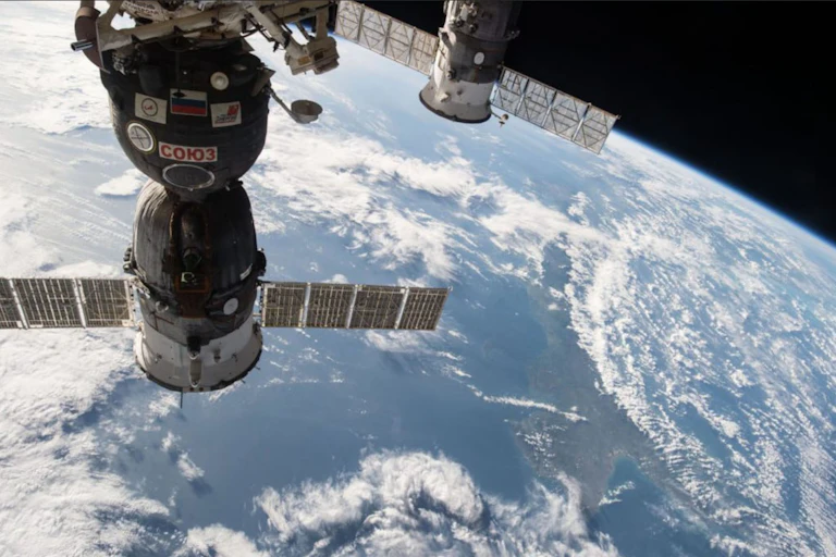 The Soyuz TMA-15M spacecraft and the ISS Progress cargo craft float above the Earth.