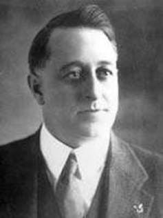 A black and white photo of a man in a suit and tie