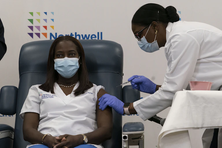 A nurse receives the COVID-19 vaccine.