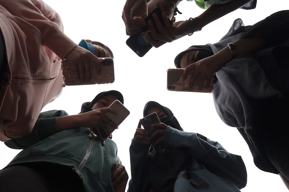 Sejumlah remaja memegang ponsel mereka masing-masing di Medan, Sumatra Utara.