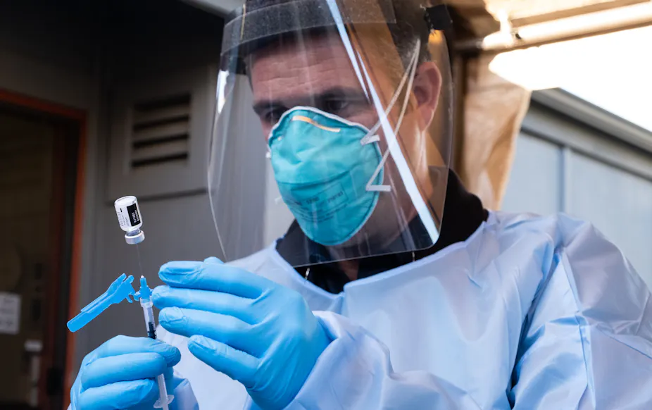 A nurse prepares to administer a dose of the Pfizer vaccine