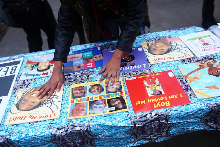 Children's books are sprawled out on a table.