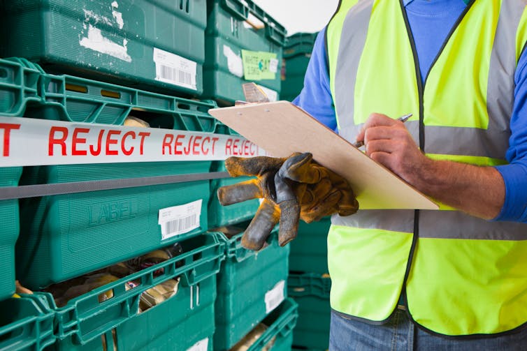 Worker with rejected produce in food processing warehouse.