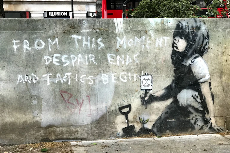 A black and white mural of a child playing in the sand