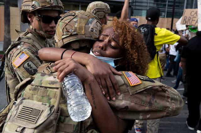 A demonstrator hugs a member of the National Guard during a march in response to George Floyd's death on June 2, 2020 in Los Angeles, California.