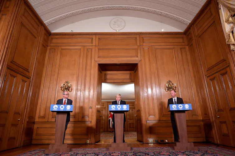 El asesor científico Sir Patrick Vallance (izquierda) y el director médico, el profesor Chris Whitty (derecha), con el primer ministro británico Boris Johnson durante una conferencia de prensa.