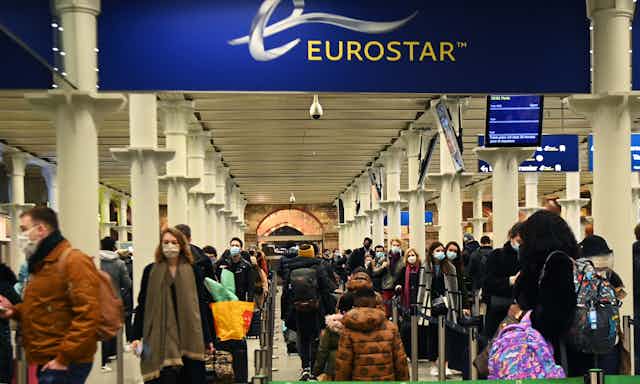 Crowd of wearing face masks at Eurostar entrance in St Pancras International