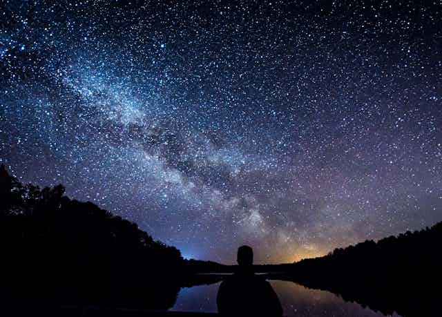 Starry sky over a lake and hills