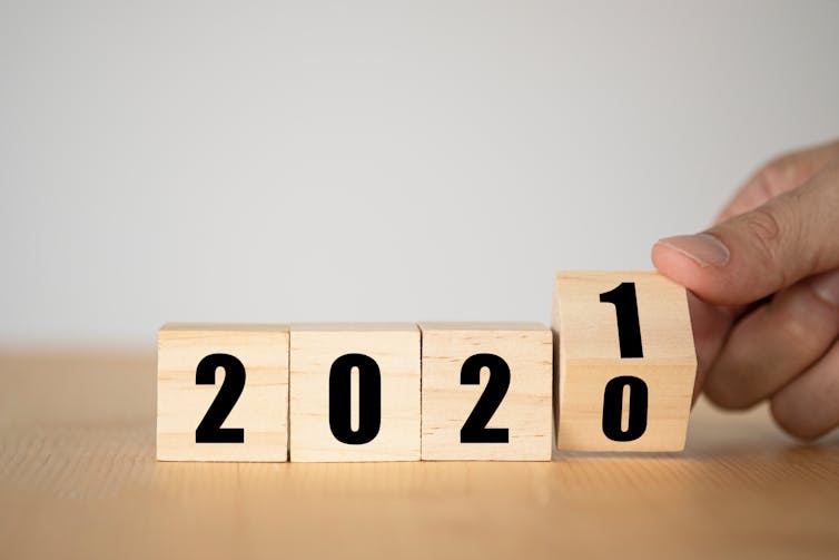Four wooden blocks spelling out '2020' with the final block flipping from 0 to 1.