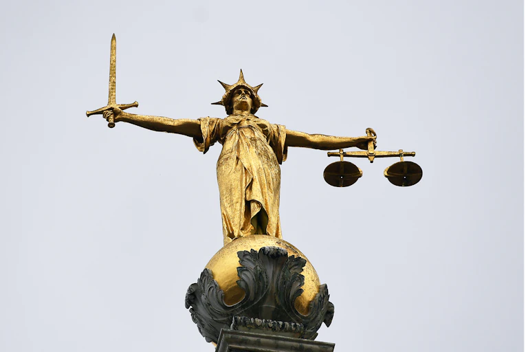Golden statue of justice holding a sword in one hand and scales in the other
