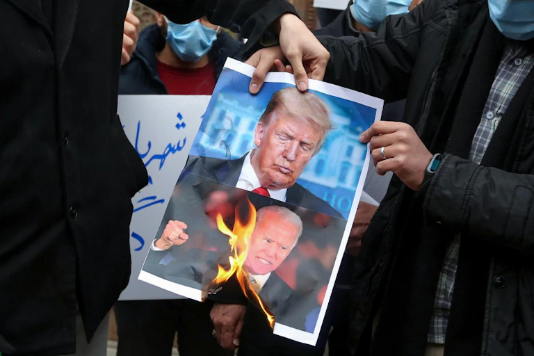 Des portraits de Donald Trump et de Joe Biden sont brûlés pendant une manifestation à Téhéran le 28 novembre 2020.