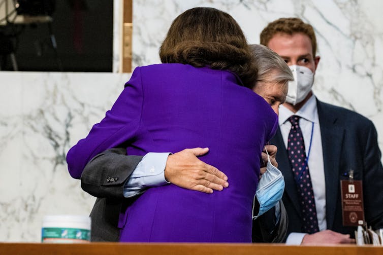 Feinstein's back as she hugs Graham