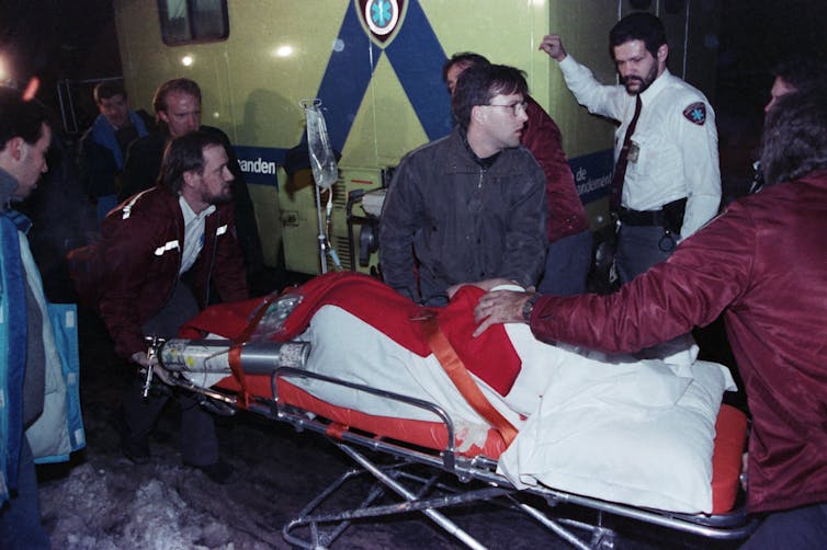 A victim on a stretcher surrounded by paramedics.
