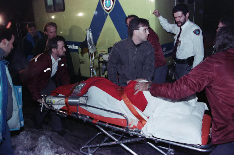 A victim on a stretcher surrounded by paramedics.