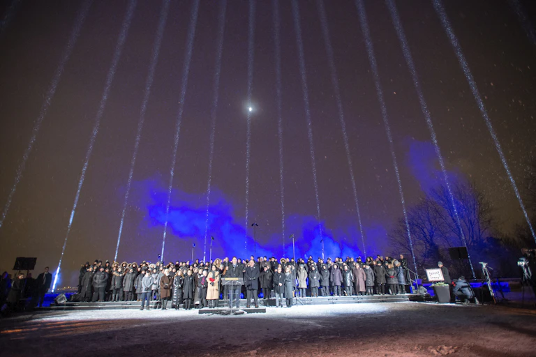 Fourteen beams of light point skyward.