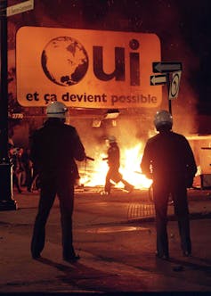 A fire burns under a Oui sign.